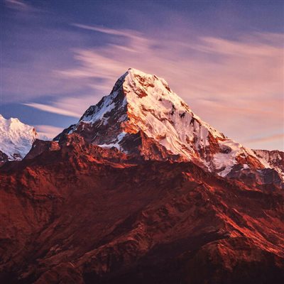 والپیپر کوهستان سرخ برفی در میان ابرها و زیر آسمان آبی